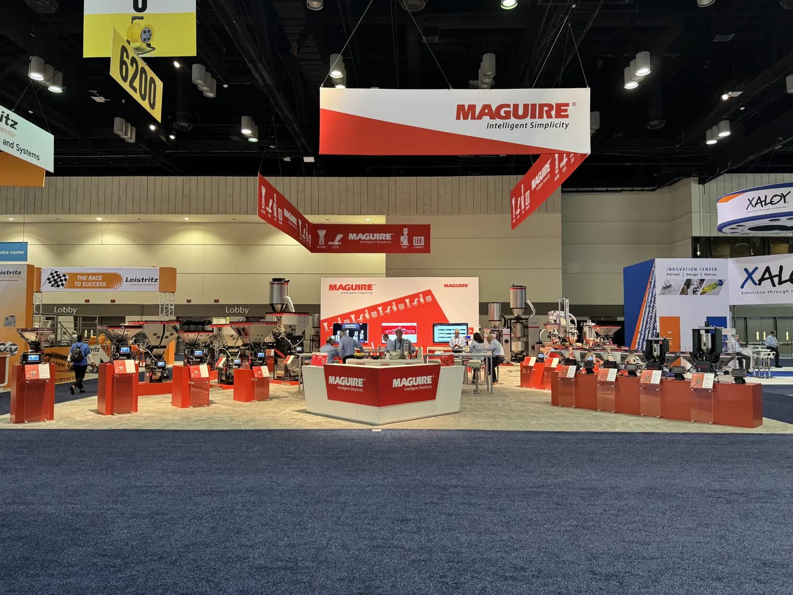 Large island exhibit with red overhead structures and multiple machinery displays.